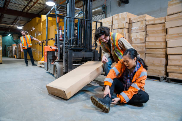 istock An industrial warehouse workplace safety topic. A worker injured falling or being struck by a forklift. 1163441135