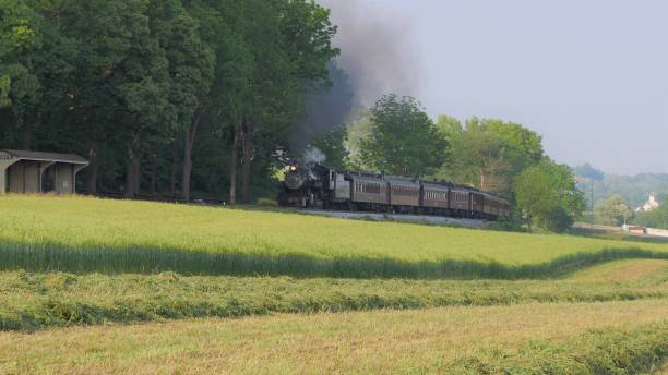 istock Steam Train pulling into Picnic Area to Dropping off Passengers on a Summer DayTrain at Picnic Area, Dropping off Passengers as Second Steam Train Passes, in Amish Countryside 1163441136