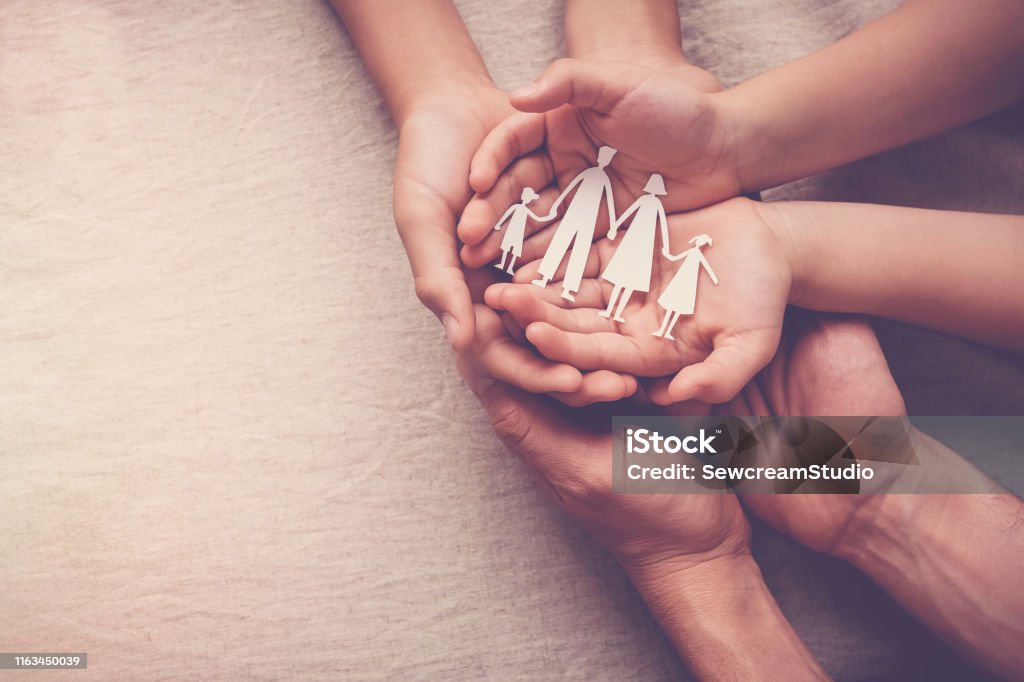 Adult and children hands holding paper family cutout, family home, foster care, homeless support concept Family Stock Photo