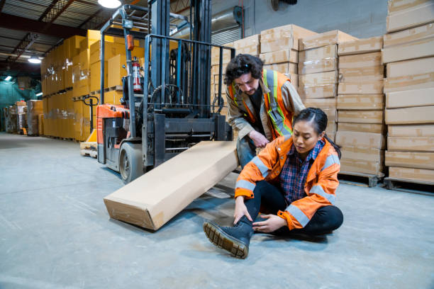 istock An industrial warehouse workplace safety topic. A worker injured falling or being struck by a forklift. 1163452206
