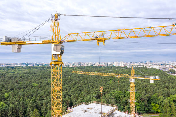 istock aerial panoramic view of modern building under construction and yellow cranes against blue sky background 1163453692
