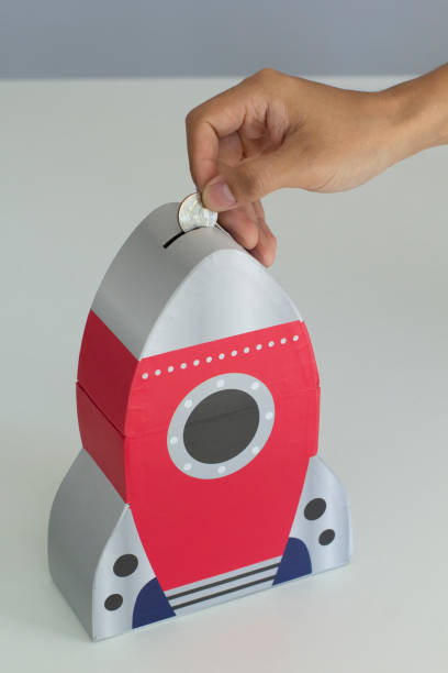 istock Saving money into coin bank 1163457016