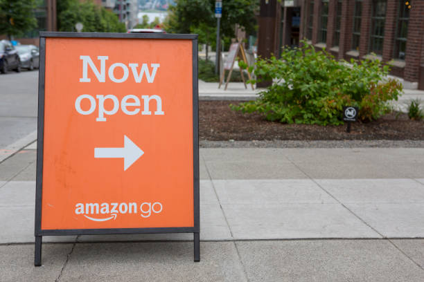Amazon Go Retail Store with Automated Contactless Payment Amazon Go, owned by Amazon.com, located in the South Lake Union district of Seattle, Washington, offers a cashierless or contactless payment.  The a-frame sign announces “now open”. convenience store stock pictures, royalty-free photos & images