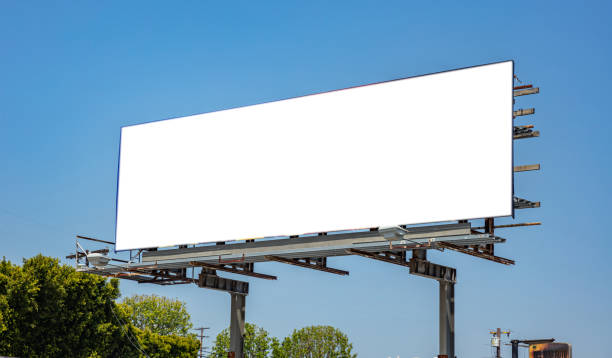 blanc de panneau-réclame sur une autoroute pour la publicité, jour ensoleillé de ressort - road sign sign blue blank photos et images de collection