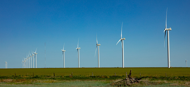 Wind farm, New Mexico, USA. Wind turbines, alternative energy plant on a green field, sunny spring day, banner
