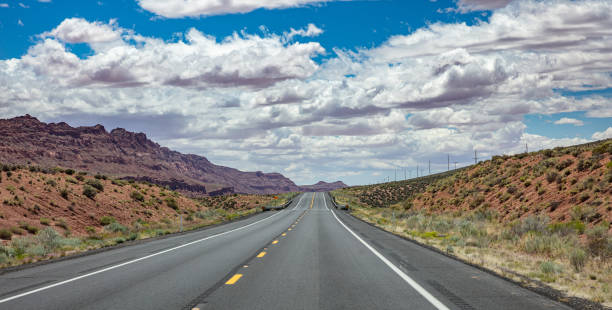 istock Long highway with ups and downs, cloudy blue sky. USA 1163458888