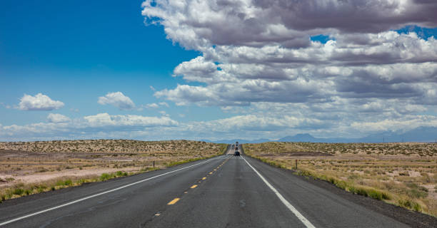 istock Long highway in the american desert, blue cloudy sky background 1163458889