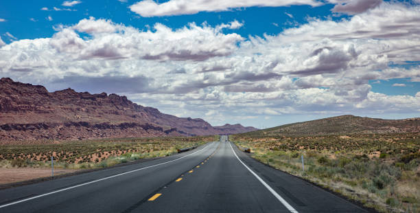 istock Long highway with ups and downs, cloudy blue sky. USA 1163458890