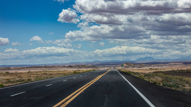 istock Long highway with ups and downs, cloudy blue sky. USA 1163458891