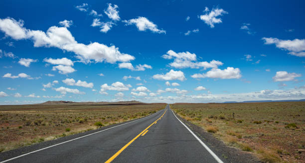 istock Long highway with ups and downs, cloudy blue sky. USA 1163458894