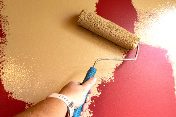 istock female hand holding paint roller DIY 1163460548