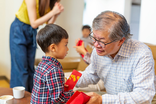 Grandfather and Grandson Giving Lucky Red Envelopes