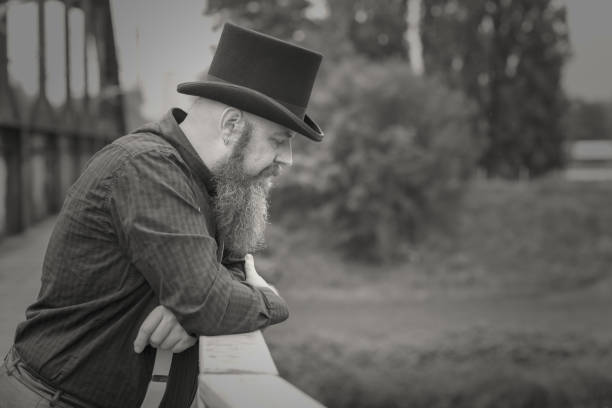 istock Bearded man in a top hat lost in deep thought 1163463671