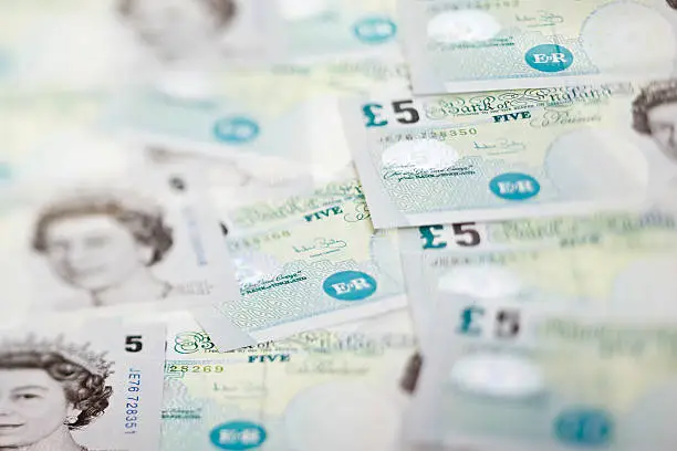 Background of brand new British five pound notes - taken with a tilt shift lens.