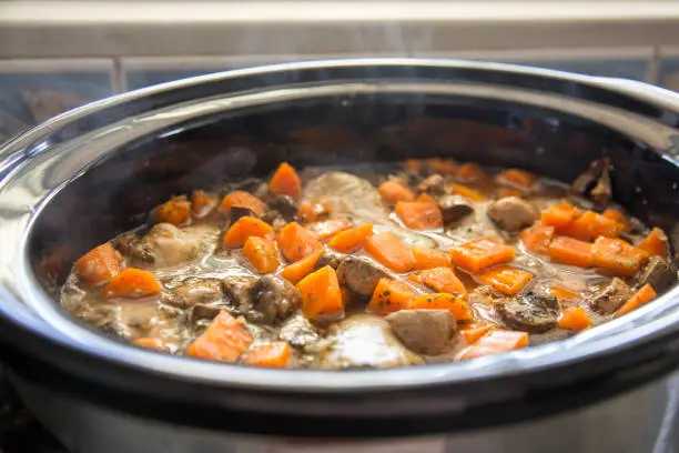 Chicken, carrots and mushrooms cooking in a slow cooker. Chicken Chasseur.