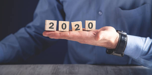 istock Man holding wooden cubes with 2020 year. 1163468518