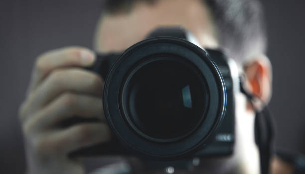 istock Professional photographer holding a DSLR camera. 1163468528