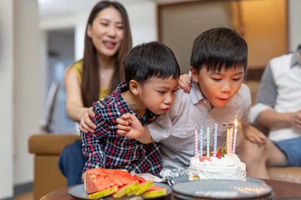 istock Young Boys Blowing Out Birthday Cake Candles 1163470311