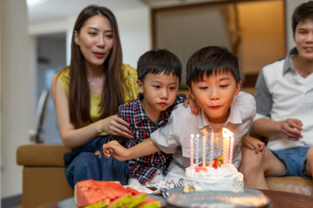 istock Young Boys Blowing Out Birthday Cake Candles 1163470366