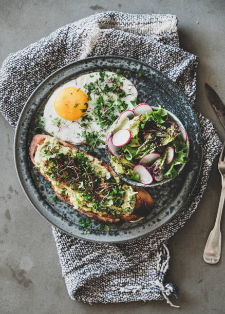 istock Healthy trendy breakfast with avocado toast, fried egg and salad 1163470959