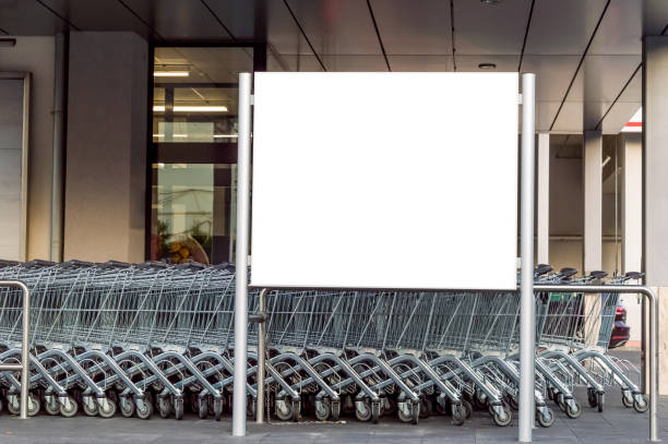 istock Blank billboard in a supermarket, next to shopping carts 1163472464