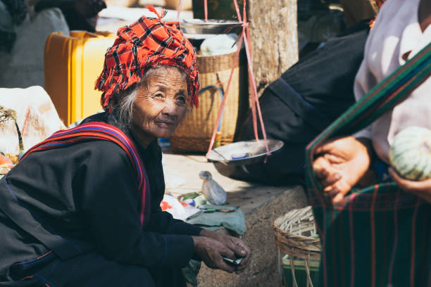 mulher burmese velha do tribo dos povos do dragão de pao no mercado de rua no lago inle em indein, myanmar - traditional culture dragon old asian culture - fotografias e filmes do acervo