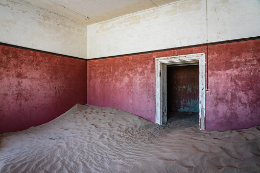 Ghost Town Scene. Desert sand entering old abandoned and broken house ín old deserted Diamond Mine Ghost Town. Kolmanskop, Luderitz, Namibia, Africa.