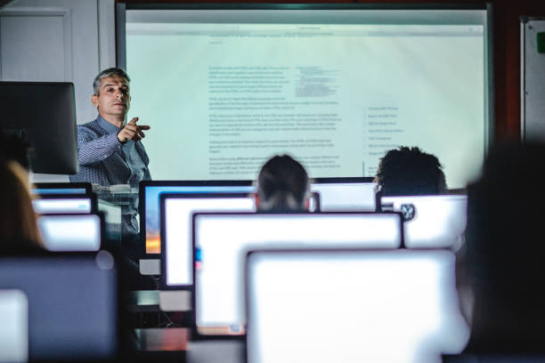 istock Mid adult teacher giving a lesson in computer lab. 1163476238