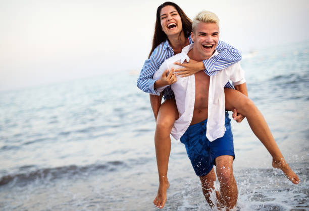istock Happy young couple having fun and love on the beach 1163476868