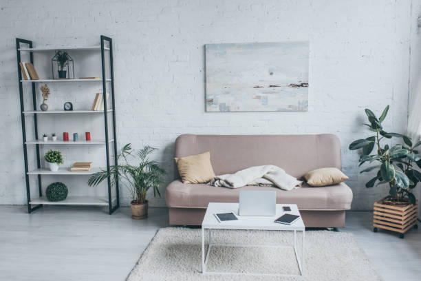 istock spacious living room with sofa, rack, plants and table with digital devices 1163477000
