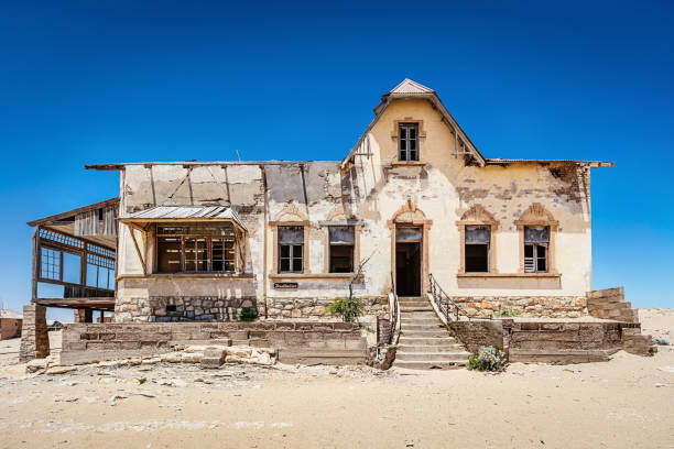 Abandoned House Ghost Town Kolmanskop Luderitz Namibia Abandoned House in Ghost Town Old Diamond Mine und deep blue desert sky. Desert sand entering the old abandoned and broken weathered house. Kolmanskop, Luderitz, Namibia, Africa. kolmanskop namibia stock pictures, royalty-free photos & images