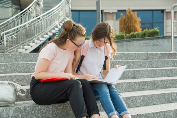 istock Two young beautiful girls students with backpacks, books 1163477885