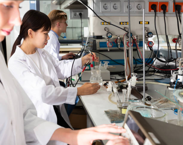 istock Positive Caucasian and Asian students at lab 1163480633
