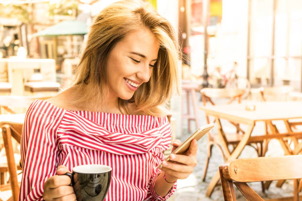 istock Beutiful girl checking her phone and having a coffee 1163481751