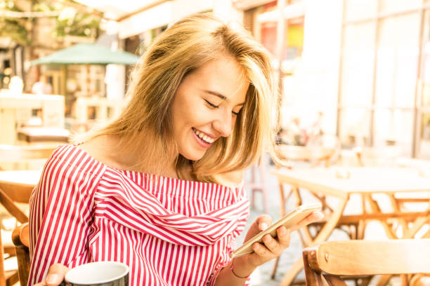 istock Beutiful girl checking her phone and having a coffee 1163481803