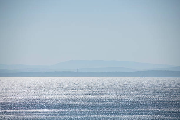 Shimmering Aegean Sea and silhouette of Turkish coastline viewed from the Greek Island of Chios. This area of Turkey (near Cesme) is where many refugees have started their dangerous travel across the Aegean Sea to Chios (or another Greek Island).