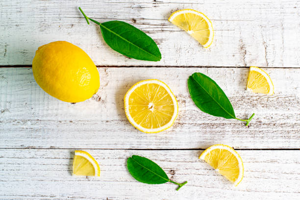 istock lemon and slices with leaf on wooden table 1163485375