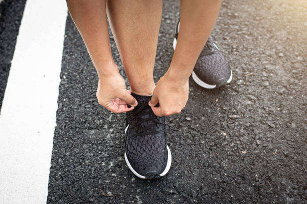 istock young woman runner tying shoelace 1163488029