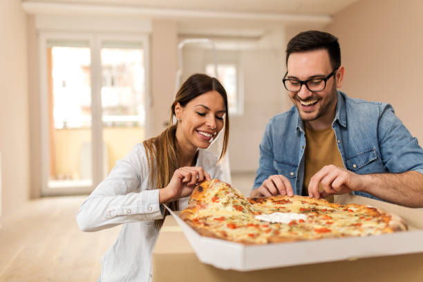 istock Happy couple eating pizza. 1163490008