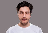 Portrait of handsome millennial man with closed eyes