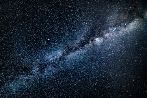 Beautiful view of the core of the Milky Way Galaxy in all its beauty as seen on a clear dark night during summer in Northern Hemisphere from Europe. Long exposure technique to capture all deep colours in the dark, shot on Canon EOS full frame system with 14mm wide prime lens. Cold white balance applied to emphasise the space like feel.