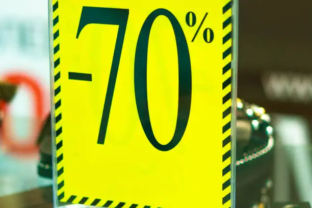 Sale sign 70 percent in a fashion clothes shop display window