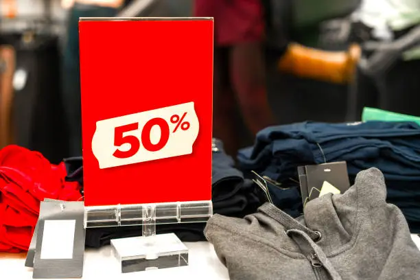 Sale sign 50 percent in a fashion clothes shop display window