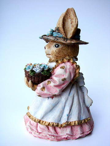 Ceramic Easter Bunny holding a basket with flowers