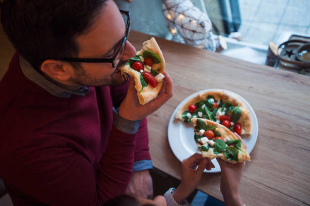 istock Close up of a man eating pizza. 1163493389