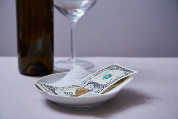 istock Restaurant tips or gratuity. Banknotes and coins on a plate 1163497268