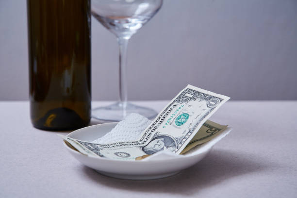 istock Restaurant tips or gratuity. Banknotes and coins on a plate 1163497269