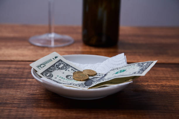 istock Restaurant tips or gratuity. Banknotes and coins on a plate 1163497280