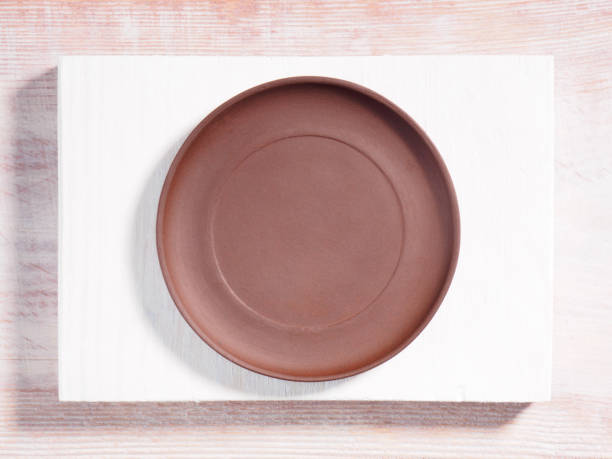 istock Brown clay plates on a wooden background 1163497296