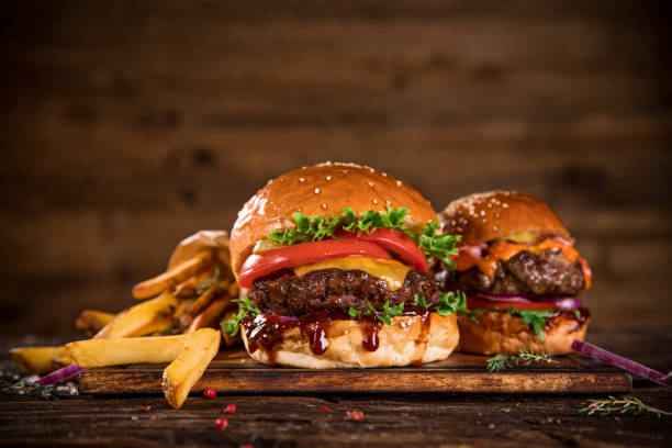 istock Tasty burgers on wooden table. 1163497341